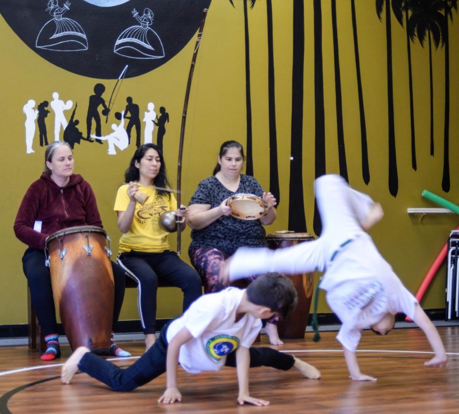 Monica Delgado plays the Berimbau as two of her students dance Capoeira at her studio, ArteLuta Capoeira Academy, on Saturday, April 15. On some ocassions, the parents of the students play beside Delgado as the children dance. (Ash Hallas | Warrior Life)