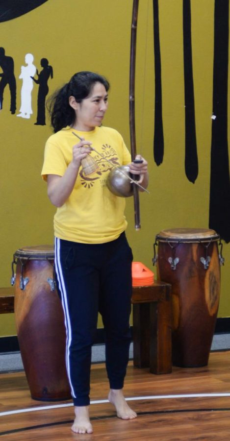 Monica Delgado plays the Berimbau as her students dance Capoeira at her studio, ArteLuta, on Saturday, April 15. (Ash Hallas | Warrior Life)