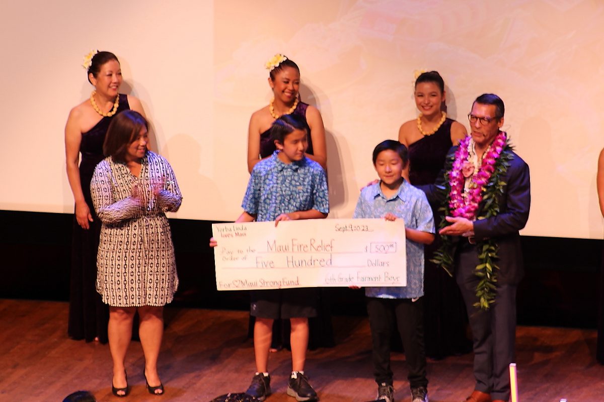 Students of Fairmont Elementary School in Yorba Linda present a $500 check  for the Maui Strong Fund to LA based news anchor and show organizer David Ono during a presentation of Defining Courage at Marsee Auditorium on Saturday, Sept. 9, 2023. (Misaki Asaba | The Union)