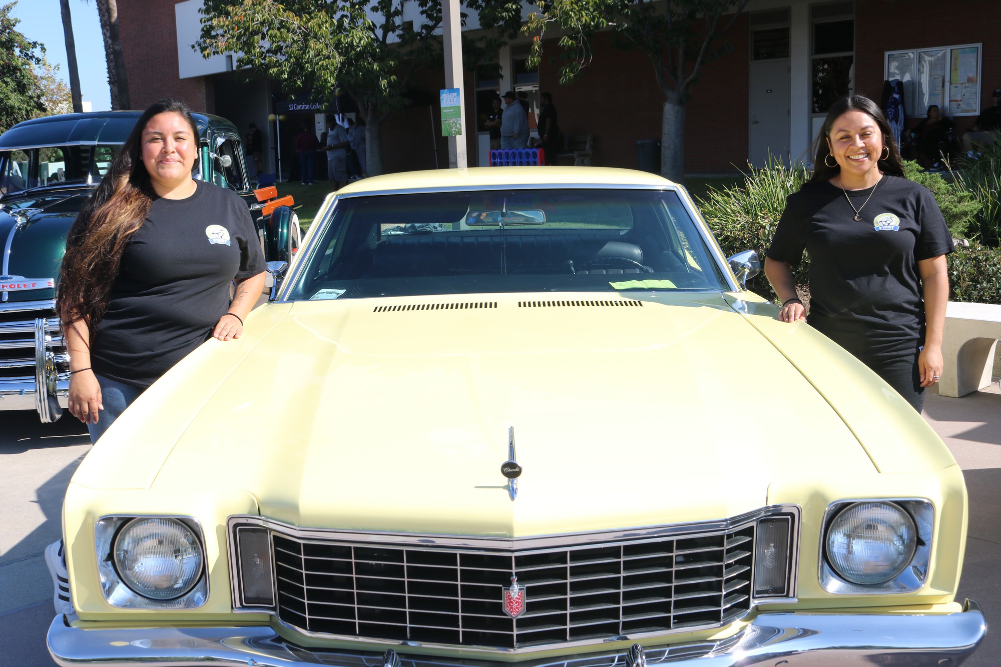 FIRST outreach specialist Isabel Gonzalez (left) poses with counselor Ruby Padilla (right) by the sides of a car on display for the programs orientation on Tuesday, Sept. 19. (Joseph Ramirez | The Union)