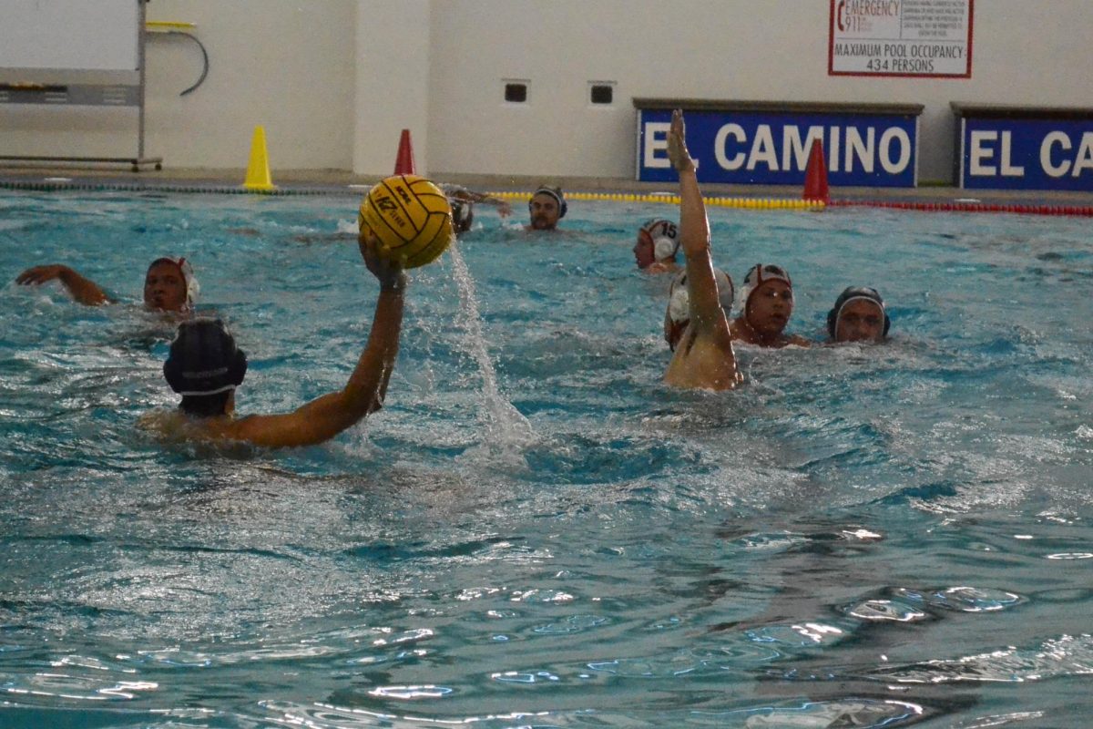 An El Camio mens water polo player attempts to make a pass against a Chaffy College water polo player on Oct.11. (Jared Abarca | The Union)