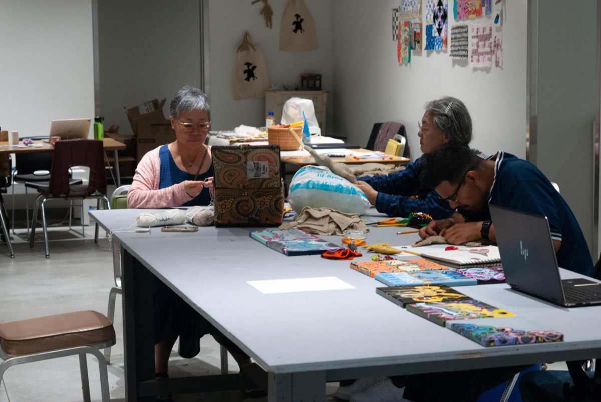 Students inside the El Camino College Art Gallery use available materials to learn sewing, crochet, and embroidery on Saturday, Sept. 9. The results of workshops can be seen on the workspace walls. (Osvin Suazo | The Union)