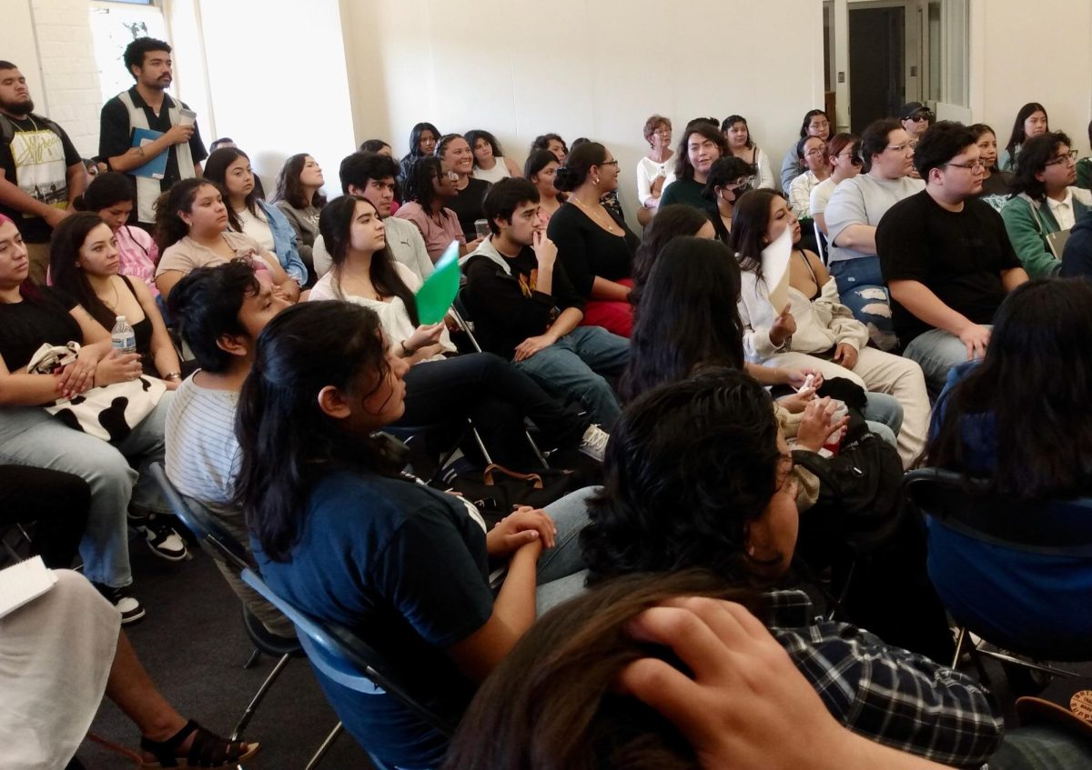 Students attending the Mi Casa Oct. 18, soft opening listen on as guest poets recite and college organizers speak. The event attracted a large crowd with some students standing outside the door as they listened and participated. (Joseph Ramirez | The Union)