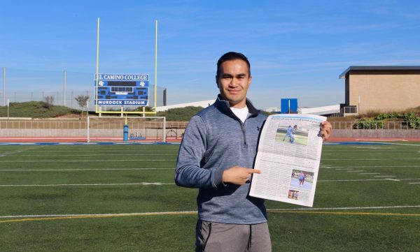 Current Warrior Life Magazine managing editor and former Union sports editor Greg Fontanilla holds up a copy of The Union featuring one of his sports pages while standing in Featherstone Field inside Murdock Stadium on Tuesday, Nov. 14. Fontanilla was awarded first pace from the California Media Association for best print sports for his work with The Union last semester. (Delfino Camacho | The Union)