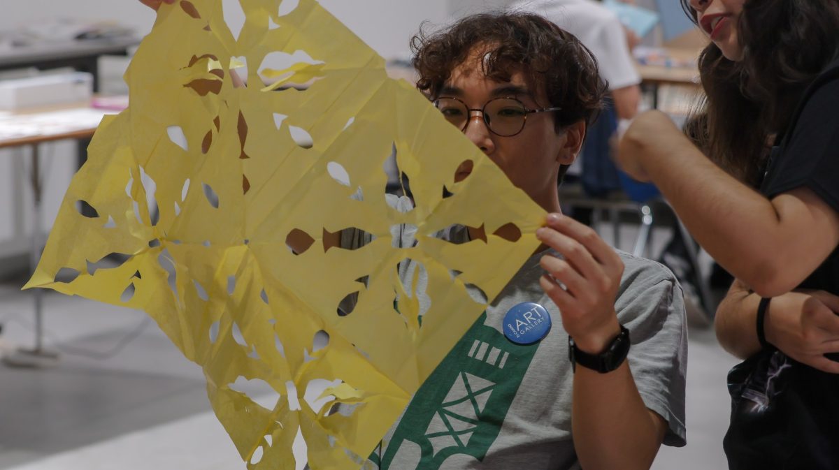 Art student Patrick Hahn revealing their design pattern during the paper mache Papel Picado workshop on Oct 19. (Ethan Balderas | The Union)