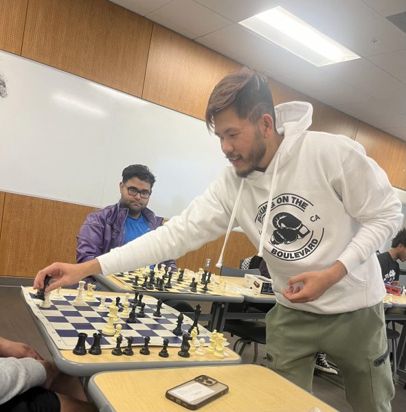 Dang Nguyen (right) as he plays chess against all of the club members during Dec.12 meeting. (Ivan Gonzalez | The Union)