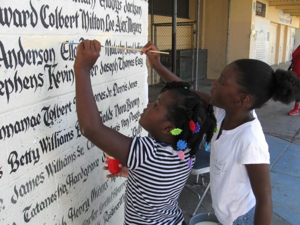 Youth at Nickerson Gardens Public Housing Development in Watts restore the names of residents who have died on the memorial walls located on the front of the recreation center on Compton Avenue just north of Imperial Highway on August 1, 2009. The walls remind people to reflect on the many young people who have lost their lives due to street or police violence, drugs, suicide and other preventable causes. Kim McGill | Warrior Life