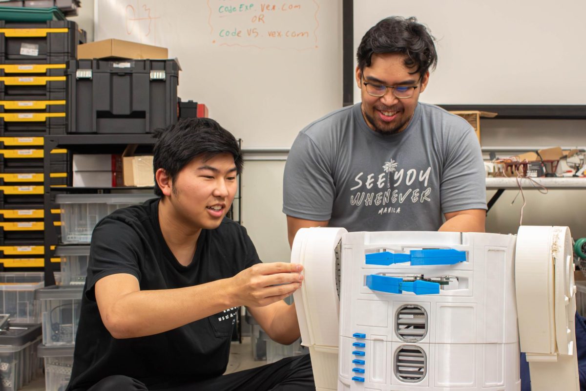 Jason Irie, left, and Joshua Molina make final checks on their R2D2 robot to prepare for the Dec. 6 robotics exhibition on Tuesday, Dec. 5. (Misaki Asaba | The Union)