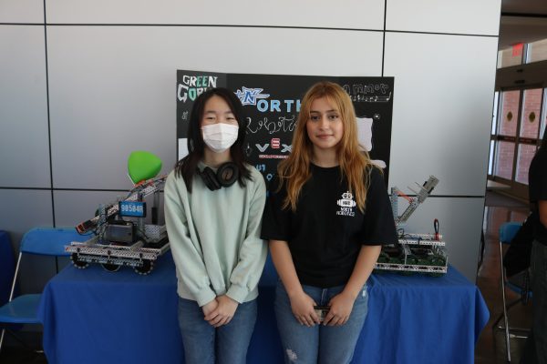North High School students and robotics club members Cheri Wang and Chelsea Salazar pose in front of their robots