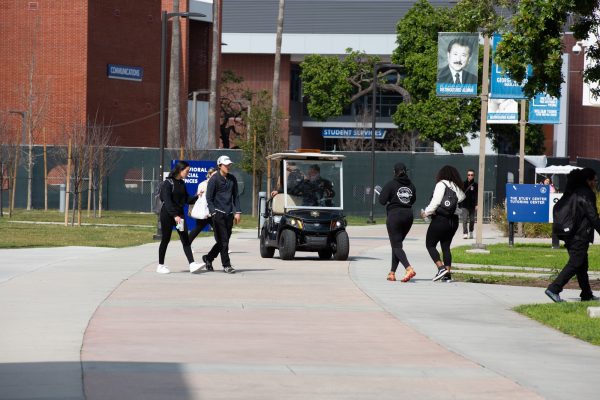 El Camino Police Sergeant Ruben Lopez waits in a golf cart for students to pass by next to the Arts Complex on Wednesday, Feb. 14, 2024. (Raphael Richardson | The Union)