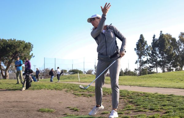 El Camino College golf instructor Kirsten Green gestures how to curve a golf swing while giving tips during her Tuesday, March 26, 8 a.m. golf class. The physical education class takes place inside the Alondra Golf Course, located near campus. (Delfino Camacho | The Union)