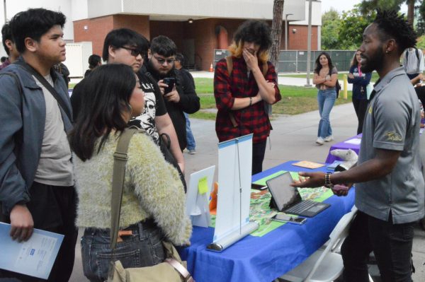 El Camino College students listen to Bryant Parker, a representative from UC Irvine, as he explains what students need to know before they transfer during the Fall University Fair by the Library Lawn on Sept. 2, 2023. (Juan Garcia | The Union)