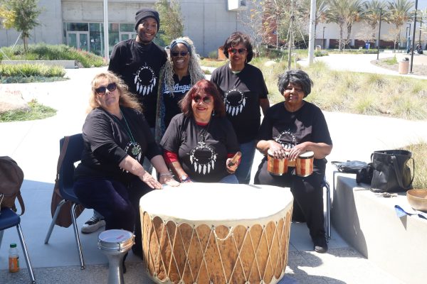 Members of United Spiritual Church in Gardena, from left, Elsa Leysack, Damon Sanders, Sharon Sanders, Suzanne Vallez, Timmie Mitchell and Carolyn Carroll, gather around the Grandmother Drum at El Camino College on Tuesday, March 19. (Jamila Zaki | The Union)