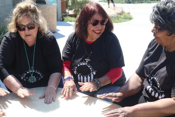 Participants, from left, Elsa Leysack, Reverend Suzanne, and Carolyn Carroll, beat the Grandmother drum to welcome the spring equinox at El Camino College on Tuesday, March 19. (Jamila Zaki | The Union)