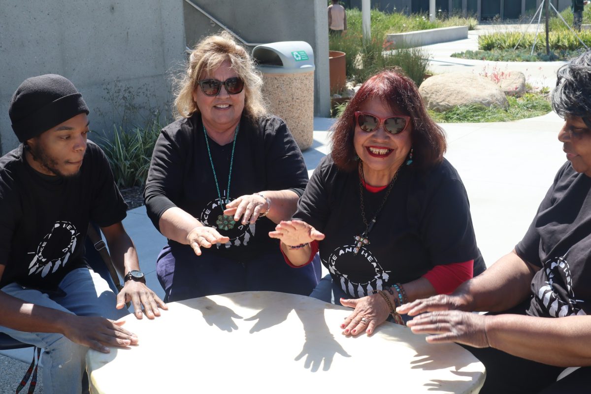 From left, participants Damon Sanders, Elsa Leysack, Suzanne Vallez and Carolyn Carroll beat the Grandmother Drum to welcome the spring equinox at the Native American Drum Circle event near the El Camino College Art Gallery on Tuesday, March 19. (Jamila Zaki | The Union)