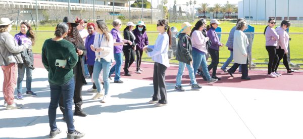 Men and women begin their walk around the PE & Athletics Field at El Camino College in celebrat