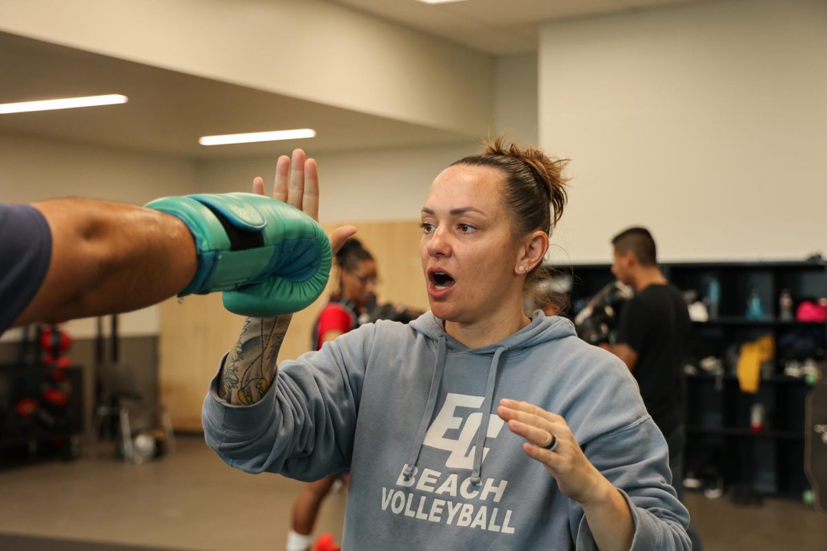 Boxing instructor, assistant coach, ECC Boxing Club adviser and Distinguished Women Award recipient Rachel Pittock demonstrates the next combination of punches to her boxing class on March 21. (Monroe Morrow | The Union)