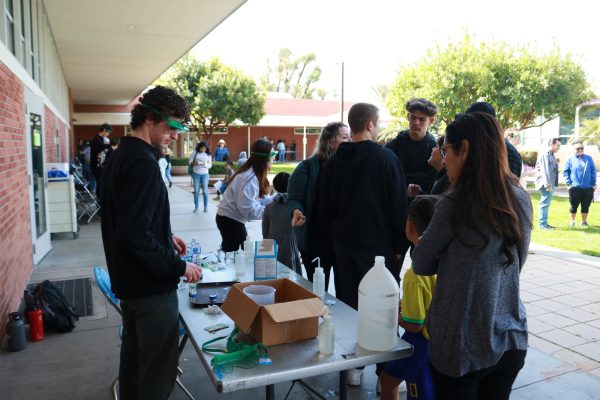 Jordan Kupner, 18, teaches children how to make bottle rockets with Alka-Seltzer in front of the Life Science Building at El Camino College on Saturday, March 16. (Joseph Ramirez | The Union)
