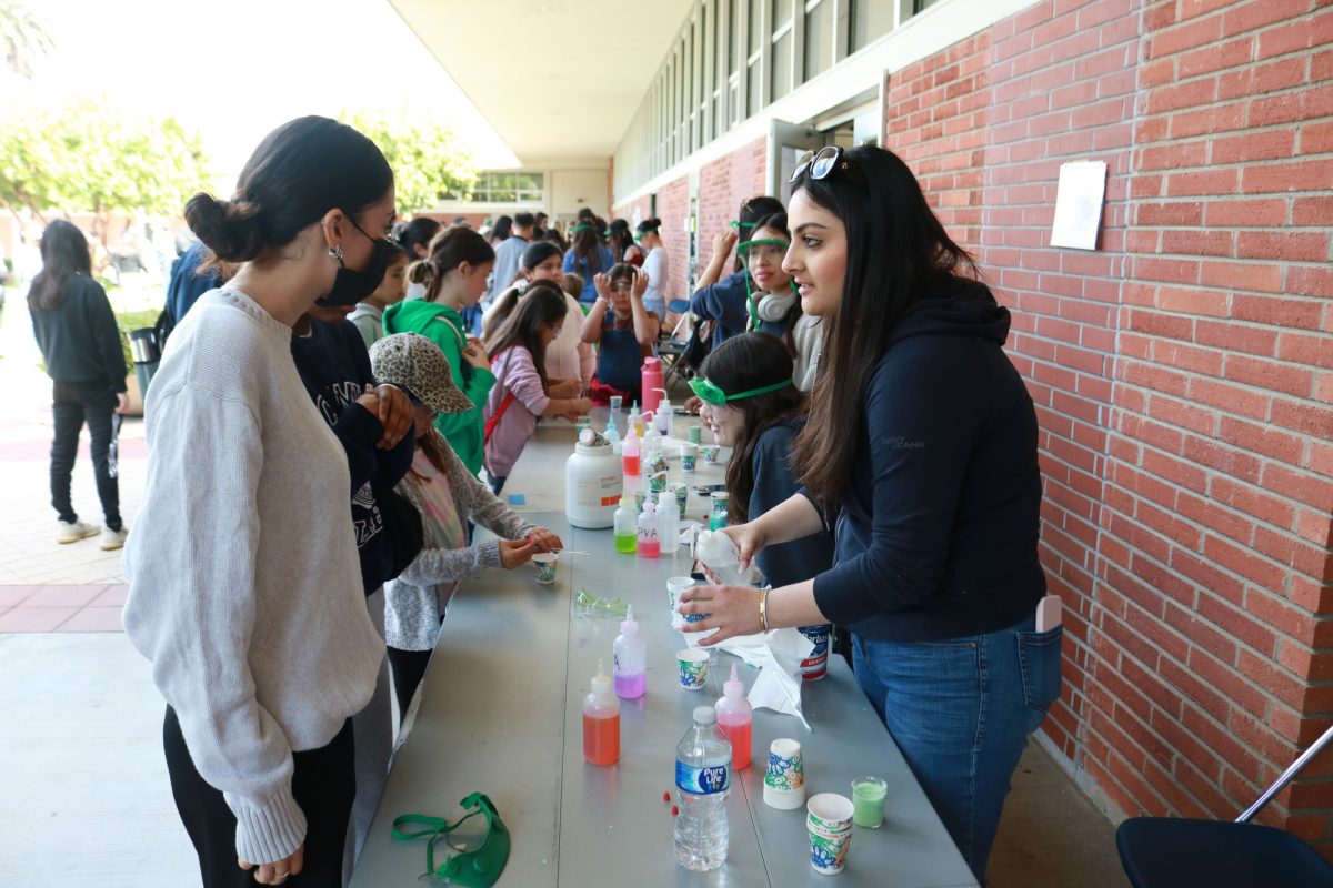 Mona Hassan, 19, teaches attendees how to make slime at the Onizuka Space Science Day on March 16, 2024 outside the Life Science Building. (Joseph Ramirez | The Union)