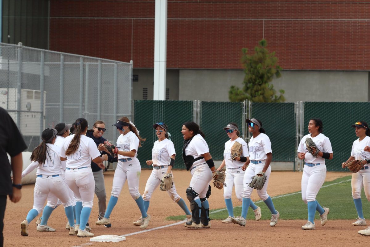 El Camino College Softball players and their coach, Jessica Rapoza, celebrate after a defensive rally to end the fifth inning in the Warriors’ 3-1 win on Thursday, April 25. (Jamila Zaki | The Union)