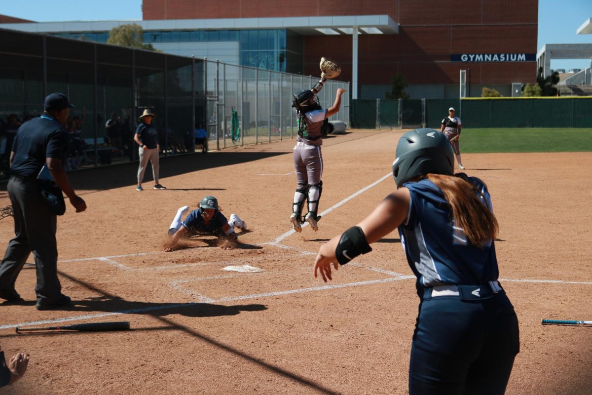Warriors infielder Cheyenne Navarro slides in the dirt and touches home plate scoring a home run during the second inning to score teammate Anahi Pintado in the Warriors 7-1 win over the Huskies on April 9. (Joseph Ramirez | The Union)