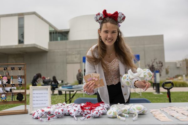 Business student Ashley Prestwood holds up her handmade Mickey Mouse ears and earrings at her table during the Maker's fair hosted outside the El Camino College Art Gallery on Monday, April 22. The event was intended for all students  to have an opportunity to sell and promote their artwork to the public. (Ethan Cohen | The Union)