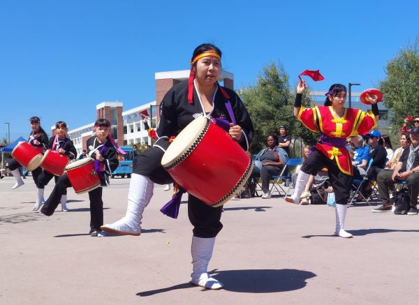 Melissa Oshirro, 20, carries a large odeiko drum as she performs with the Los Angeles branch of Ryukyukoku Matsuri Daiko during the Cherry Blossom Festival at El Camino College on Tuesday, April 2. (Nikki Yunker | The Union)