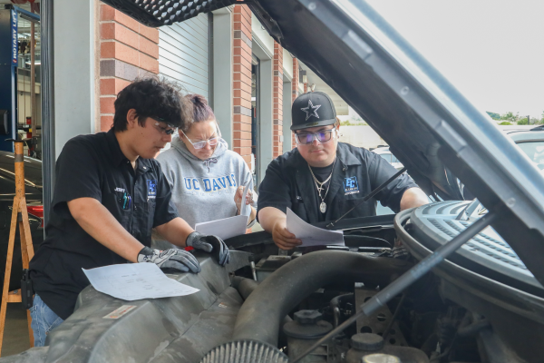 Automotive technology students Gerardo Diaz (left), Leah Braly, and Charlie Leon attempt to locate a sensor in the engine of a Ford F-150 during a lab session for an Electrical, Electronics and Computer Controlled Systems class on Monday, April 22 in the Center of Applied Technology Building. David Gonzales, dean of the Industry and Technology Division, said the automotive program can prepare students for a smog license exam. (Greg Fontanilla | Warrior Life)