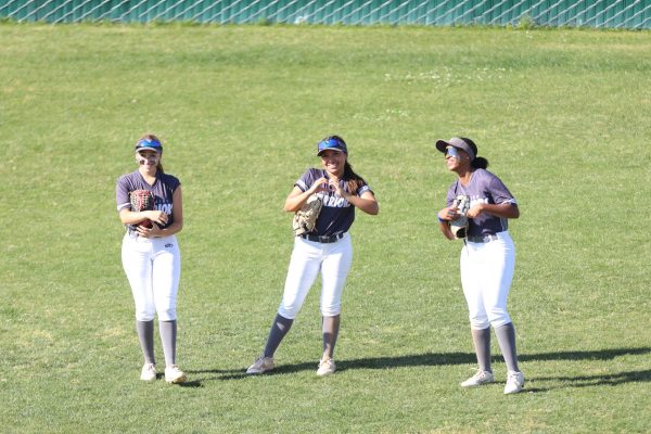 From left to right: Anahi Pintado, Jacqueline Ordonez and Malia Martin share a smile during a game against Compton College on ECC's softball field on Tuesday, April 23. (Greg Fontanilla | Warrior Life)