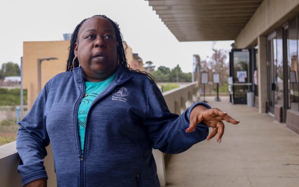 Sharonda Barksdale, who manages the Basic Needs Center at El Camino College, talks with students while standing in front of the Warrior Closet and Warrior Pantry on April 26. The closet and the pantry are found above the Bookstore. (Delfino Camacho | The Union)