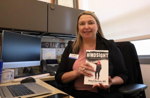 Associate Dean of Counseling and Student Success Kristina Martinez holds up the book Hindsight by Sheryl Recinos which was gifted to her by Sharonda Barksdale on Monday, March 18.