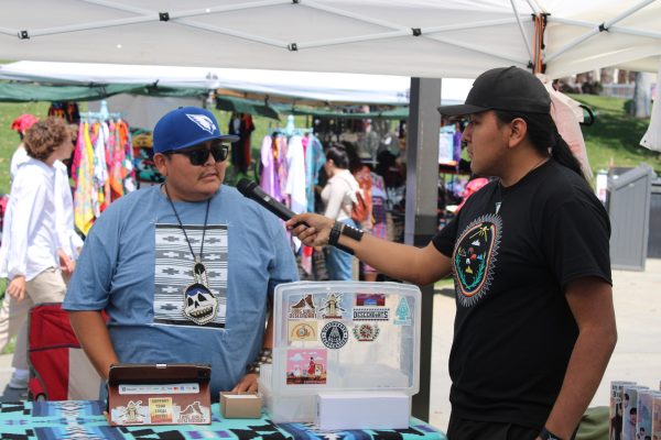 El Camino College film major Tyler Notah (R) interviews Descendants apparel booth owner Bryan Gatewood at the 11th Annual Native American Indian Pow Wow at California State University, Dominguez Hills in Carson, Calif., on Sunday, April 21. Notah is a content creator with over 44,000 followers on his TikTok channel @native.hustle. (Elsa Rosales | Warrior Life)