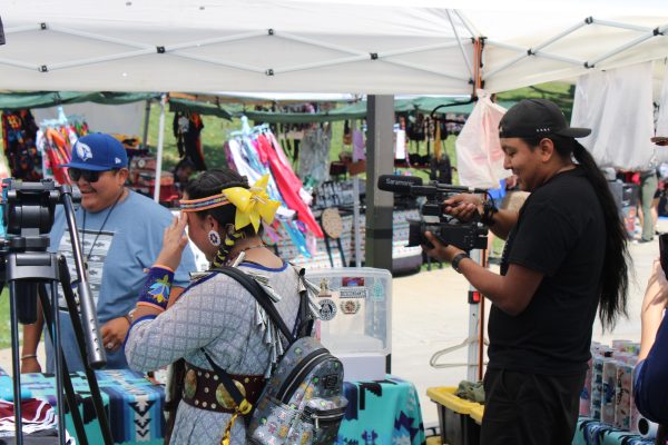 El Camino College film major Tyler Notah (R) films Descendants apparel booth owner Bryan Gatewood at the 11th Annual Native American Indian Pow Wow at California State University, Dominguez Hills in Carson, Calif., on Sunday, April 21. Notah is a content creator with over 44,000 followers on his TikTok channel @native.hustle. (Elsa Rosales | Warrior Life)