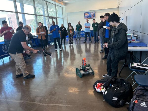 Robotics student Chad Tari demonstrates his robot C Tank to the attendees at the Robotics Exhibition. (Tommy Kallman | The Union)
