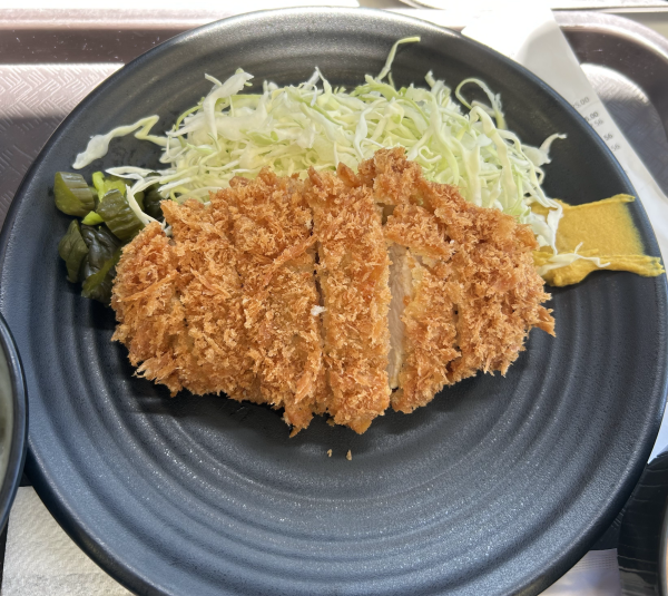 A plate of chicken katsu at Kagura in Tokyo Central. The crispiness of the chicken is seen in the outdoor seating lighting. (Tommy Kallman | Warrior Life)