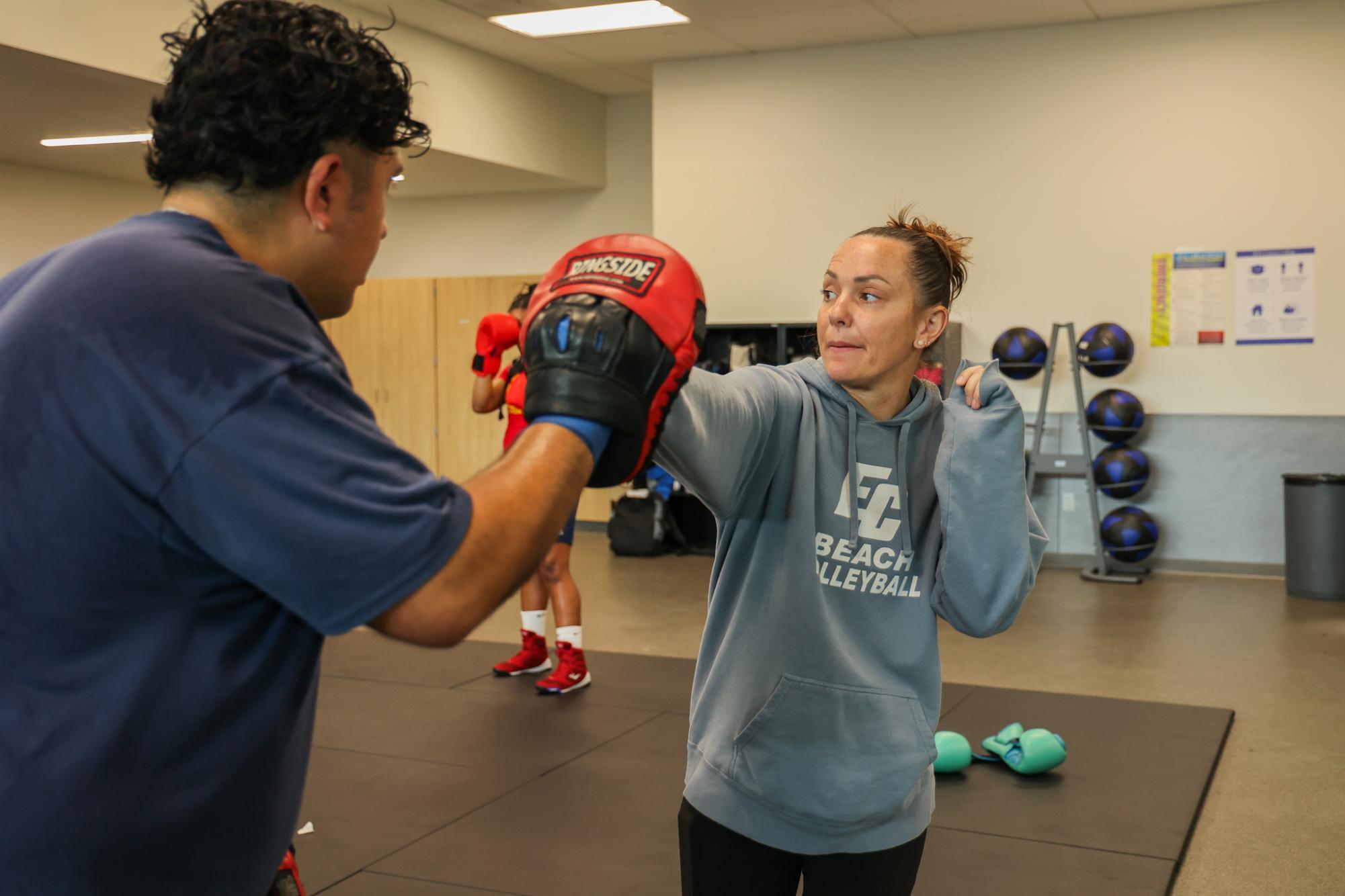 El Camino College's boxing instructor Rachel Pittock demonstrates a punching combo with a student on Thursday, March 21. (Monroe Morrow | The Union)