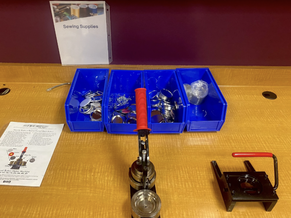 Above is a manual button maker machine, one of the sewing supplies provided by the Makerspace. Buttons are also provided for students to create their own.