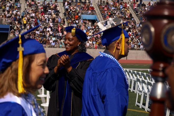 Standing on the sidelines as students march past President Brenda Thames, and other faculty, cheer on the graduating class of spring 2024 as they take their seats during the Friday, June 7 graduation ceremony. (Delfino Camachp | The Union)