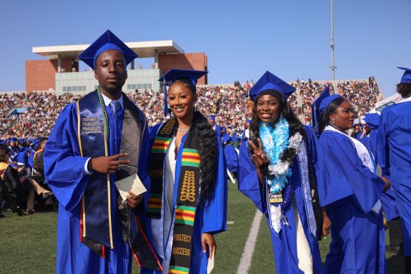 Students flash a smile while waiting in line to receive their diplomas from distinguished El Camino faculty and staff during the El Camino College June 7 graduation ceremony. (Delfino Camacho | The Union)