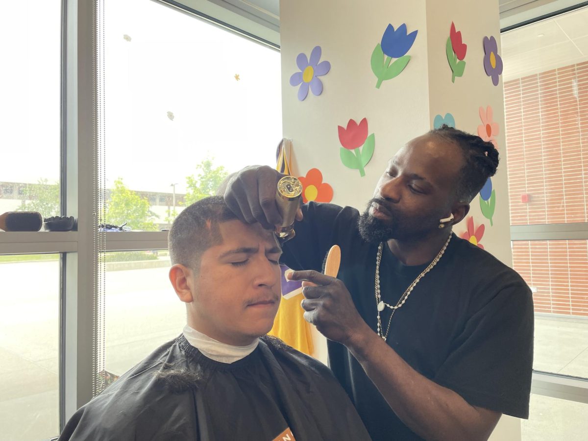 Machinist major Anthony Martinez, left, receives his free haircut from independent barber Kevin McClain at the Dr. Parrish Geary’s Barbershop Talks event hosted by Men of Color Action Network on Wednesday, May 22. (Joshua Flores | The Union)