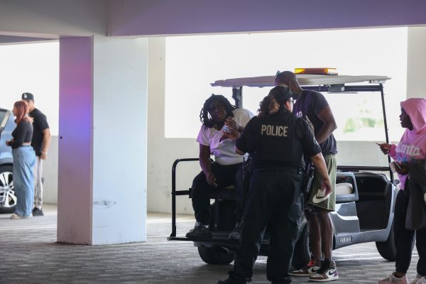 The victim in a physical altercation is attended to by an El Camino College Police Department officer in Lot C on Thursday, Sept. 12 on the third floor of the parking lot where the altercation took place. (Greg Fontanilla | The Union)