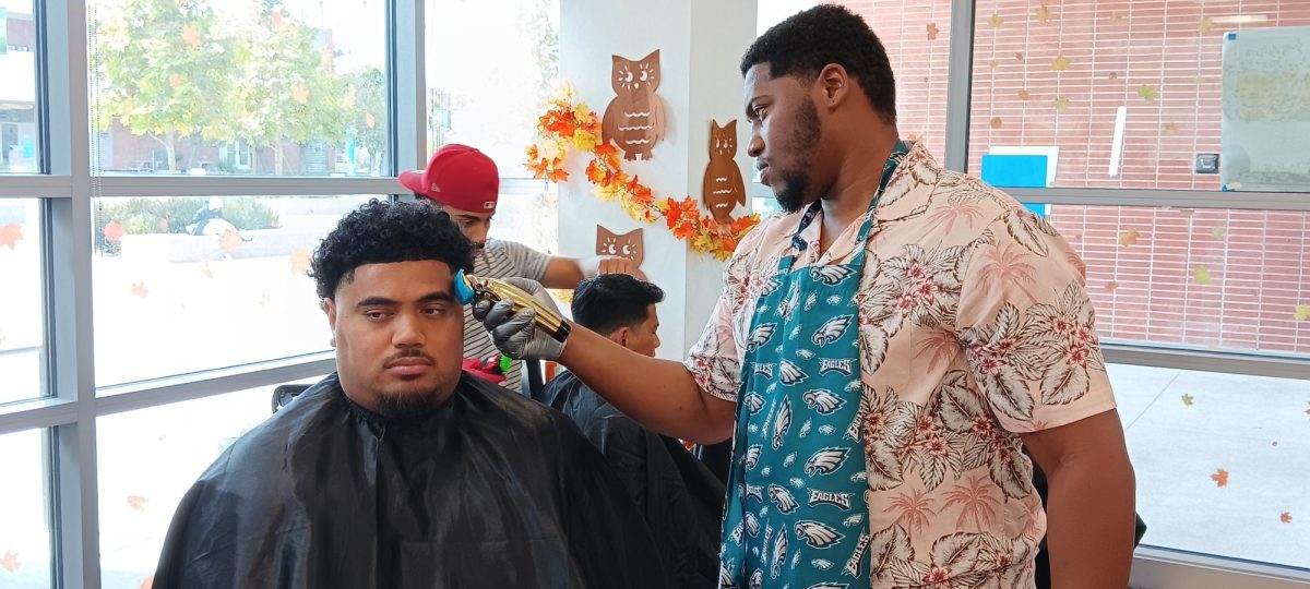 Barber Alajowan Edwards gives a haircut during Dr. Parrish Geary's Barbershop Talks hosted by the Men of Color Action Network on Wednesday, Sept. 18 at the Student Equity and Achievement Center. (Elliott Bullock II | The Union)