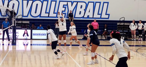 Warrior's Perla Lopez(9) sets the ball for Yasmine Watanabe(5) to spike against the Cubs.