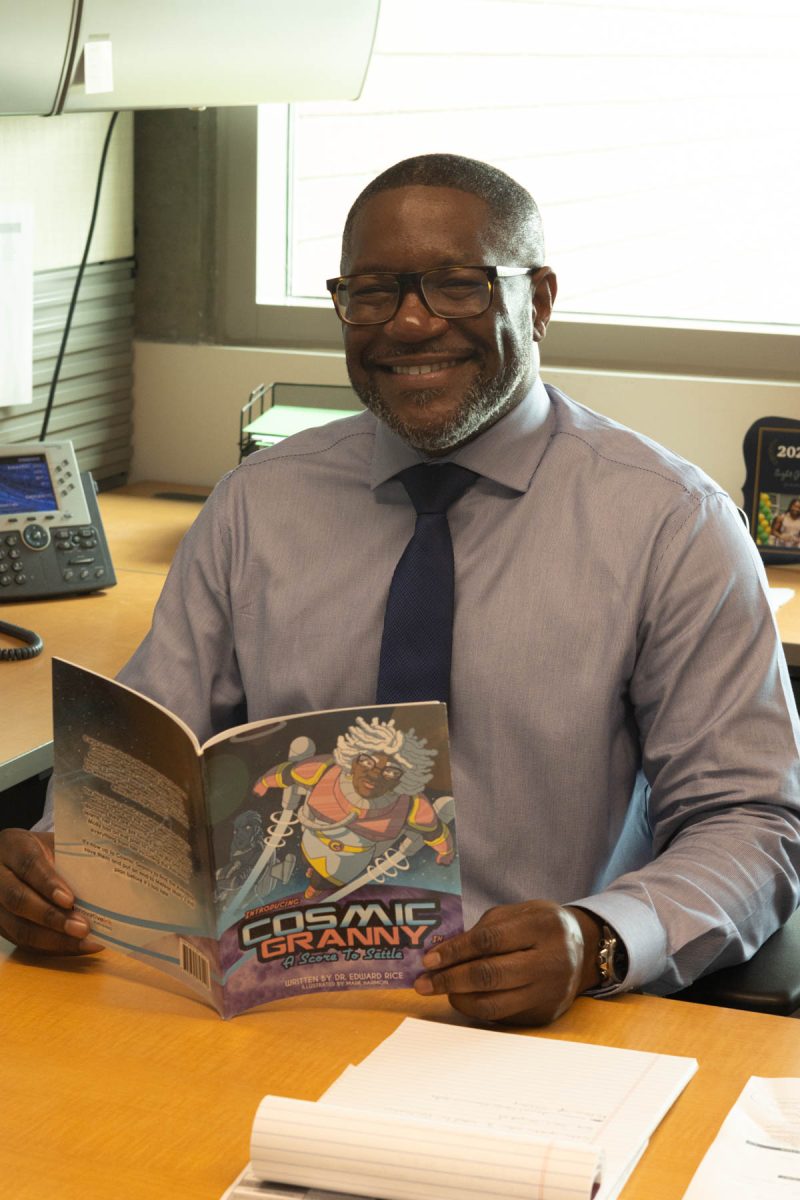 El Camino College’s new Associate Dean of Humanities Edward Rice with his debut book, Cosmic Granny, in his office on Oct. 14. Cosmic Granny tells the story of retired space commander Norma Gnarly and her adventures with her grandchildren. (Katie Gronenthal | The Union)