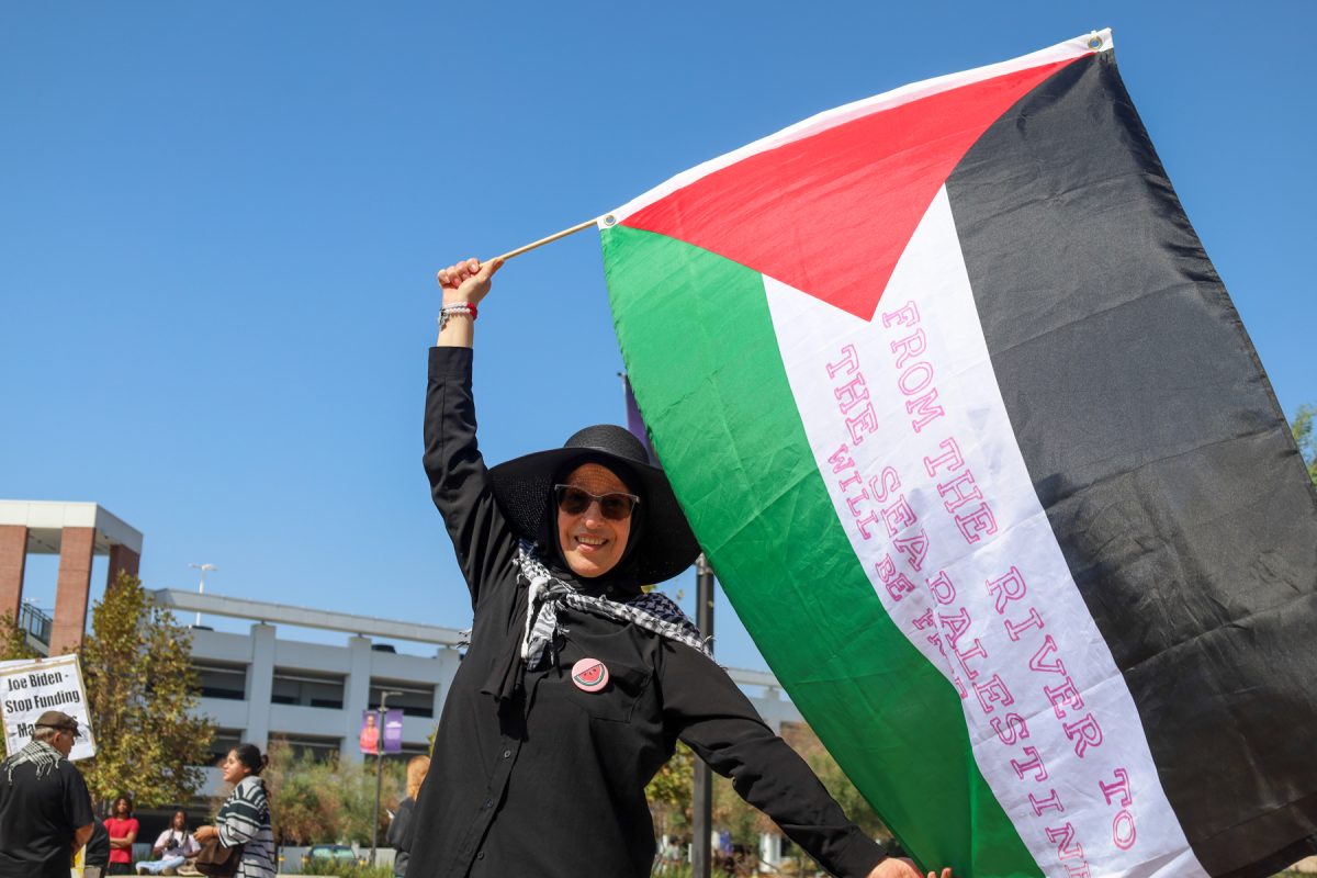 Munira Shatarah, a 61-year-old Palestinian from Jaffa and a nursing major, demonstrates the Palestinian flag at a Palestine rally at El Camino College on Oct. 8, 2024. Shatarah said it's "miserable" for those living in Gaza, as families are killed and people are left in poor humanitarian conditions. She added that the land belonged to Palestine, and that they would get it back soon. “[It’s] not their [Israel's] country, it’s our country," she said. (Angela Osorio | The Union)