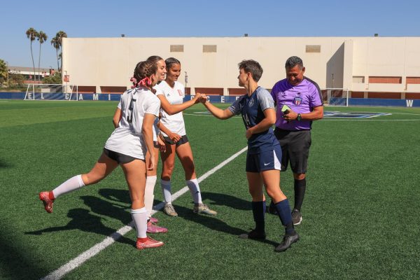 (L-R) Long Beach City College Vikings defender Abbie Campos, forward Kiana Moore and defender Danika Hunter greet El Camino College Warriors forward Claire Mahon after the coin toss conducted by referee Gilberto Rocha on the ECC Soccer Field on Friday, Oct. 18, 2024. The coin toss determined the Warriors would take the south net for the first half. (Elsa Rosales | The Union)