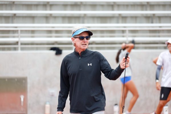 With a handheld stopwatch in hand, longtime track and field and cross-country coach Dean Lofgren prepares to send long-distance runners out for intervals on the track at Murdock Stadium on Wednesday, Oct. 16. Lofgren will be calling it a career at El Camino College after almost 40 years of coaching. (Greg Fontanilla | The Union)