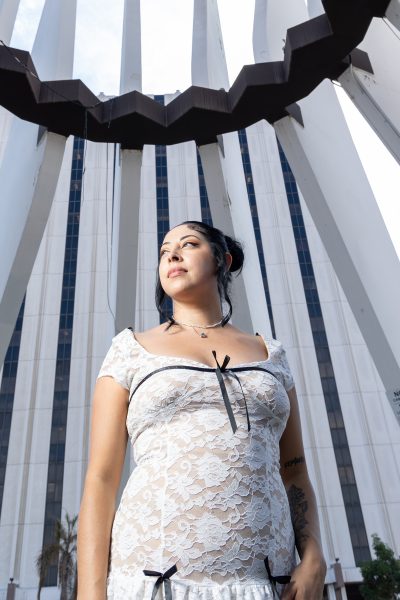 Ashley Mendoza, 32, looks to her right at the King Memorial in front of the Compton Courthouse on Oct. 27, 2024. Mendoza got her fashion design and merchandising degree at El Camino College in spring 2024, the first in her family to graduate from college. “[I am] a first-generation Chicana that graduated from college that also overcame homelessness, depression, and battling with my mental health while attending college and graduating with a 3.2,” Mendoza said. (Eddy Cermeno | Warrior Life)