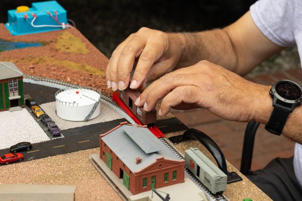 Belmont Shore Model Railroad club member Norman Harris uses a special tool to align the wheels of a model train car onto the tracks. The club specializes in N scale models, which require precision to create and run. The club displayed their models at the Lomita Railroad Museum's Children's Day on Sept. 21 2024 to encourage children to explore the hobby. (Katie Gronenthal | The Union)