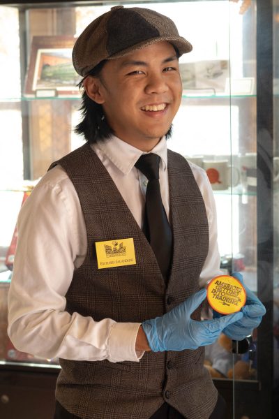 El Camino Student Richard Jalandoni holds an Amtrak Button in the Lomita Railroad Museum on Oct 13 2024. The button reads "America&squot;s Getting Into Training" and was sold in the 1970s. The Museum holds a variety of Amtrak merchandise among other artifacts. (Katie Gronenthal | The Union)